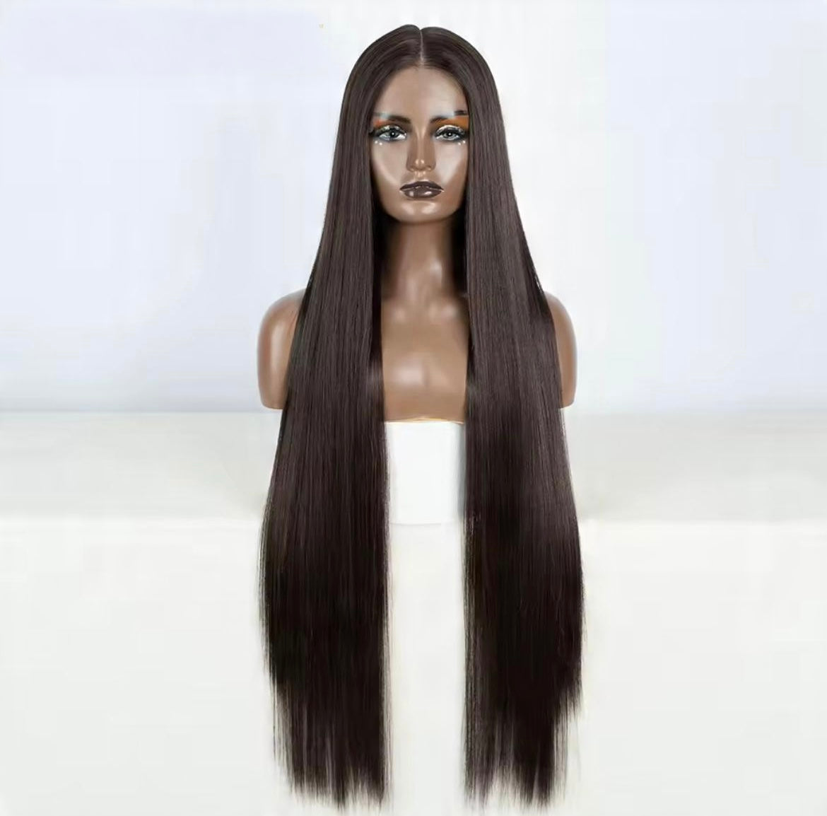 Mannequin head with long straight brown wig on a white background